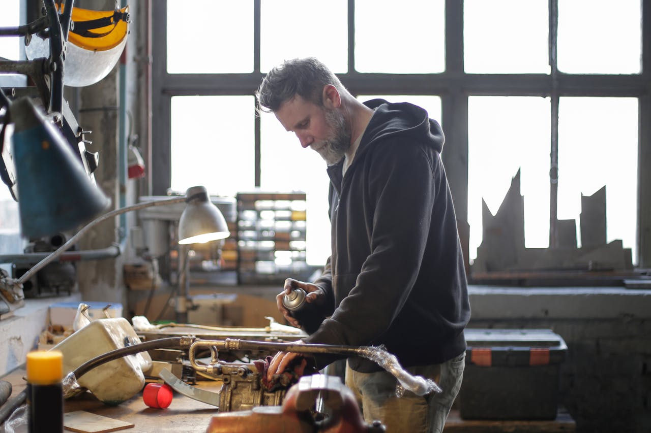 photo of a man working on something inside his garage.